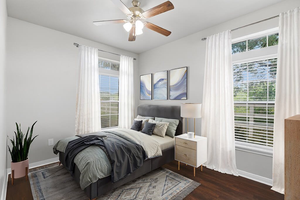 Bedroom with two windows at Almeda Park Apartments in Houston TX